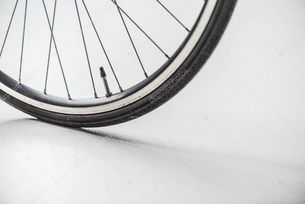 bicycle wheel with rim, tire and spokes with valve on white