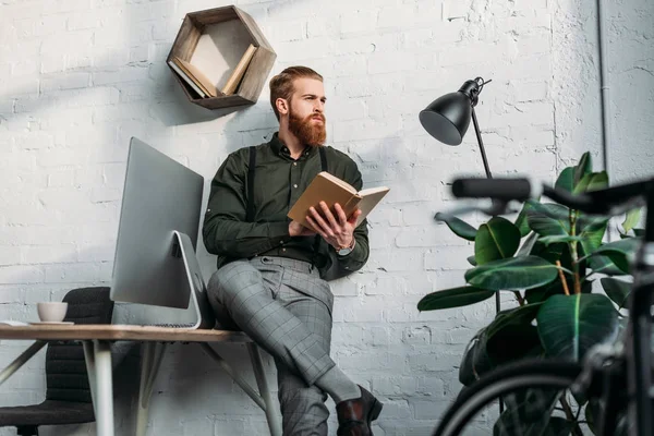 Businessman Leaning Table Holding Book Looking Away — Stock Photo, Image