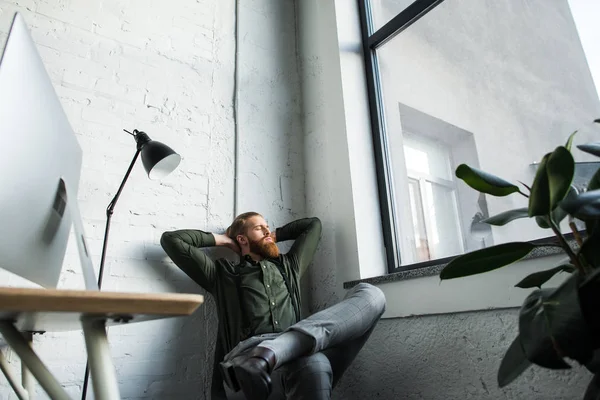 Geschäftsmann Sitzt Mit Den Händen Hinter Dem Kopf Büro — kostenloses Stockfoto