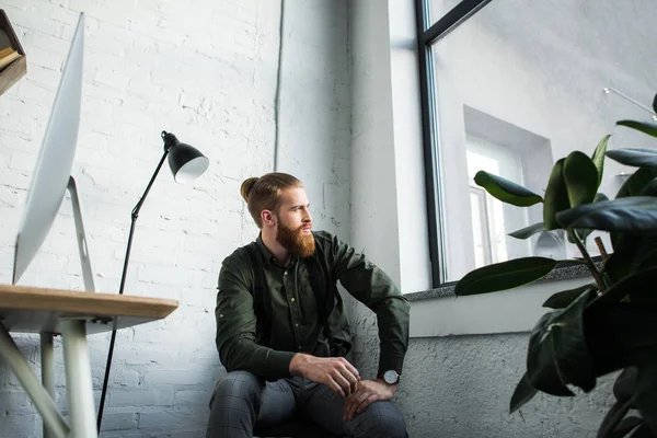 Guapo Barbudo Hombre Negocios Sentado Oficina Mirando Hacia Otro Lado — Foto de stock gratis