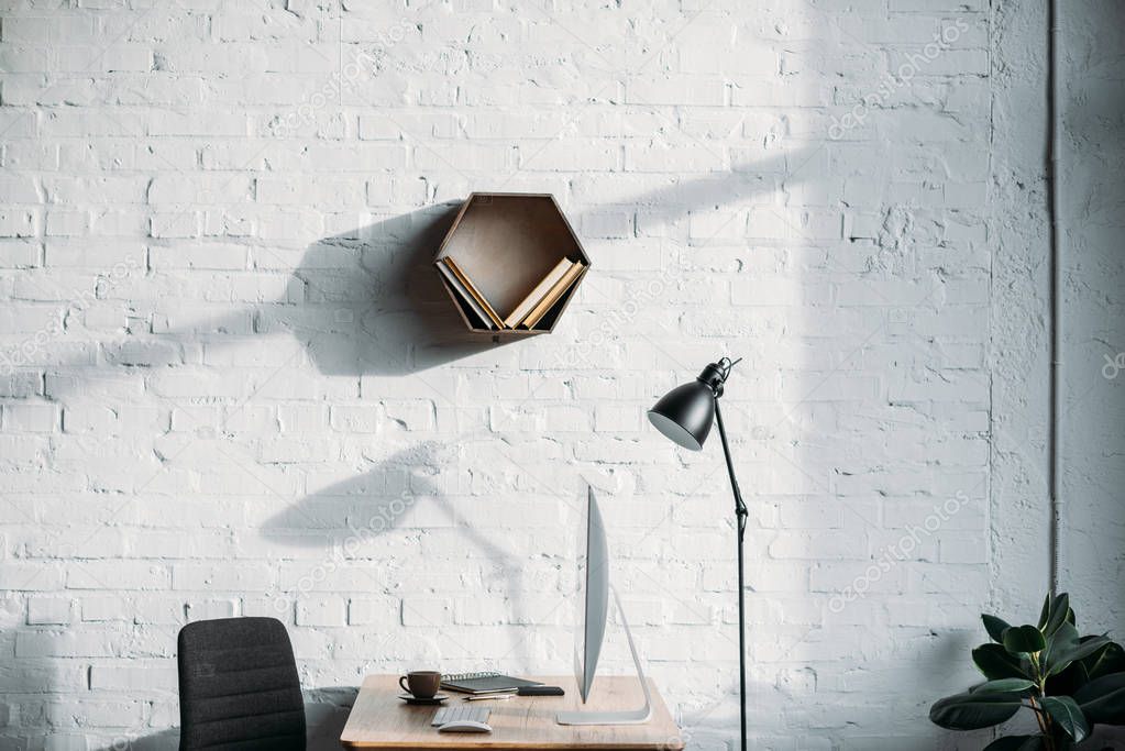 table lamp, computer and shelf on wall in office