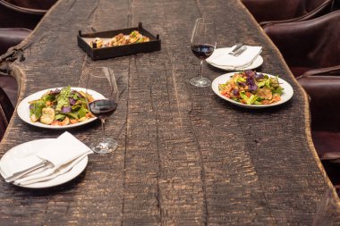 delicious salad with wine on rustic wooden table for romantic dinner clipart
