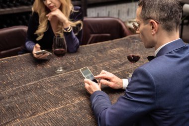 akıllı telefonlar tarihte restoranda kullanarak mutsuz yetişkin çift