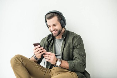 beyaz izole smartphone ile yakışıklı gülümseyen adam dinleme müzik