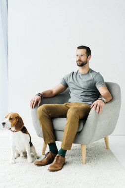 koltukta oturan ve köpek katta oturan adam