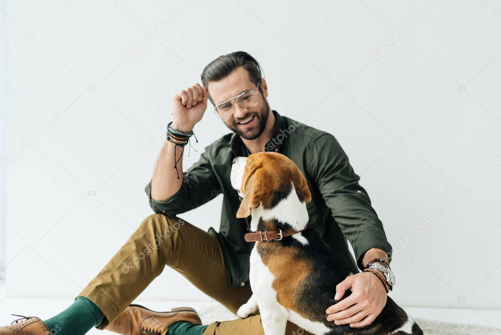 handsome smiling man palming dog on carpet