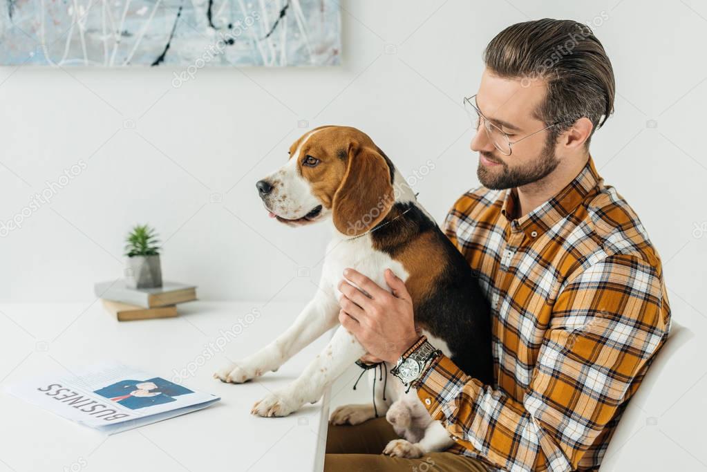 side view of businessman holding cute beagle