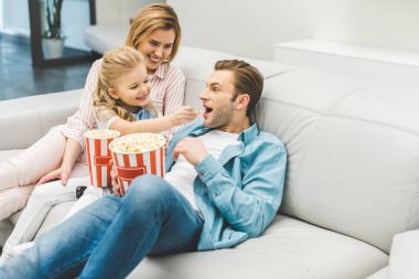 mutlu bir aile ile birlikte evde film izlerken patlamış mısır