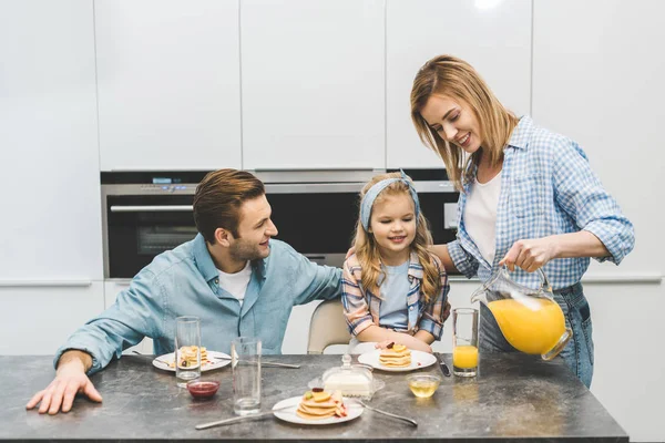 Retrato Mujer Vertiendo Jugo Vaso Durante Desayuno Con Familia Casa — Foto de Stock