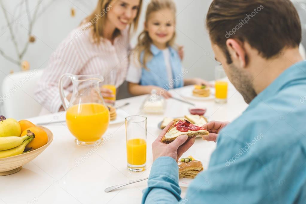 selective focus of man having breakfast together with family at home