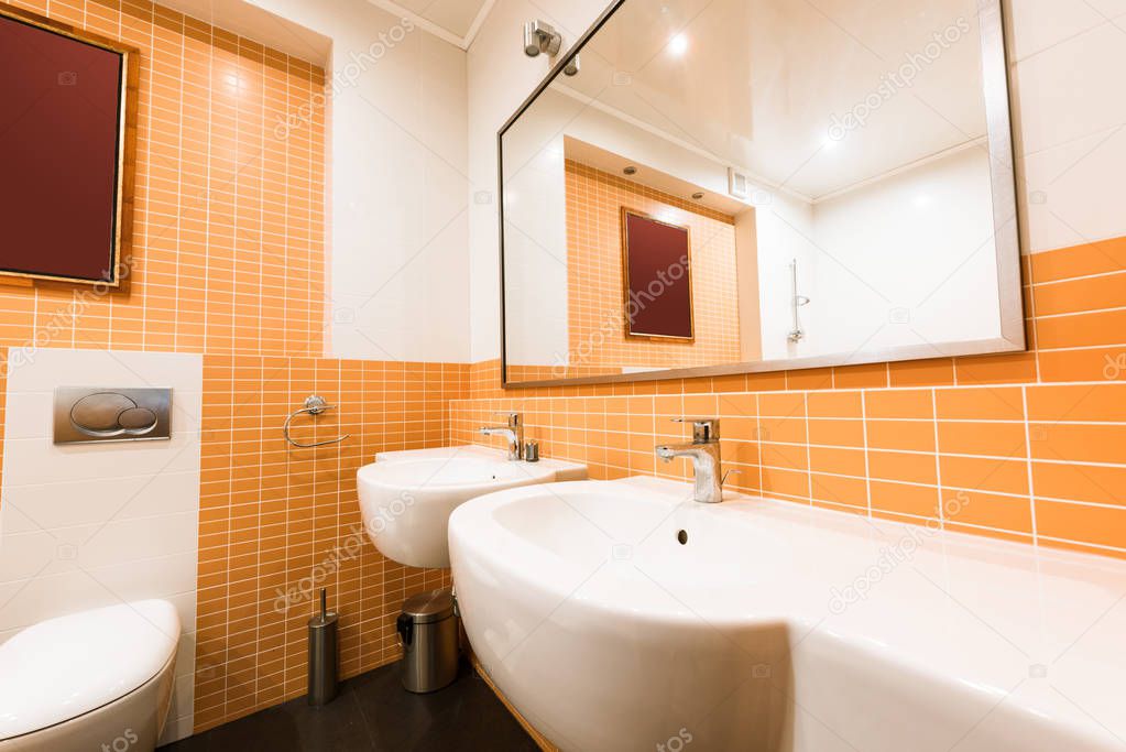 close up view of modern bathroom in orange and white colors