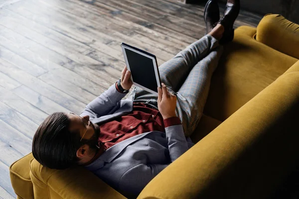 Homem Elegante Usando Tablet Digital Enquanto Deitado Sofá — Fotografia de Stock