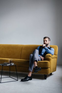 alkol içki masasında ile sarı koltukta oturan yakışıklı adam
