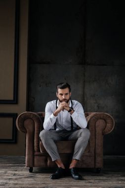 düşünme ve koltukta oturan şık yakışıklı