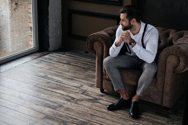 Schöner Stylischer Mann Sitzt Sessel Und Schaut Auf Fenster Loft — Stockfoto