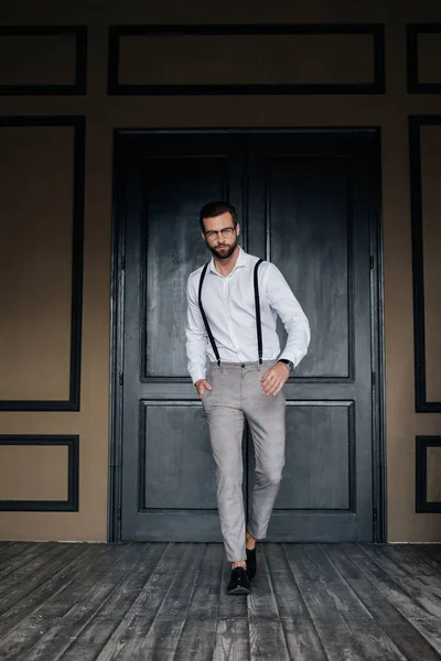 Przystojny Elegancki Mężczyzna Pozowanie Białej Koszuli Szelki Przed Drzwi — Zdjęcie stockowe
