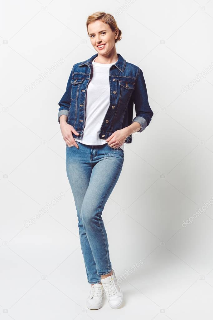 beautiful smiling woman in denim clothing looking at camera isolated on grey