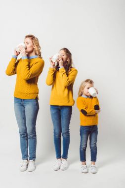 mother and daughters drinking coffee together on white clipart