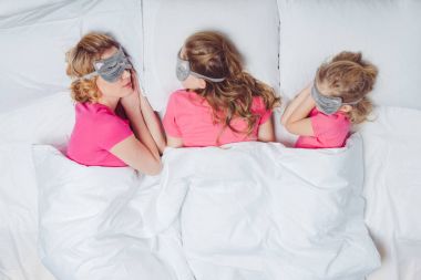 Anne ve kızı yatakta yatmaya kedisi yüzleri şeklinde maskeleri uyku ile Üstten Görünüm