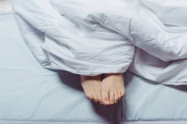 cropped shot of female feet underneath blanket  clipart