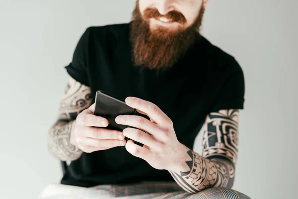 Imagem Cortada Homem Tatuado Barbudo Usando Smartphone Isolado Cinza — Fotografia de Stock