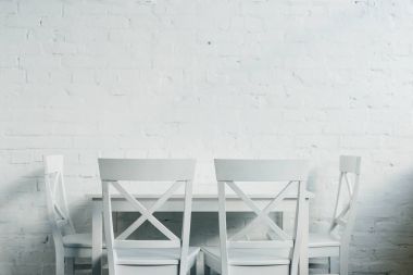 İç ahşap masa ve sandalyeler önünde tuğla duvar ile yemek odası