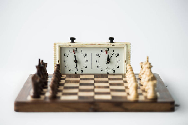 Chess clock and chess board with figures set for new game isolated on white