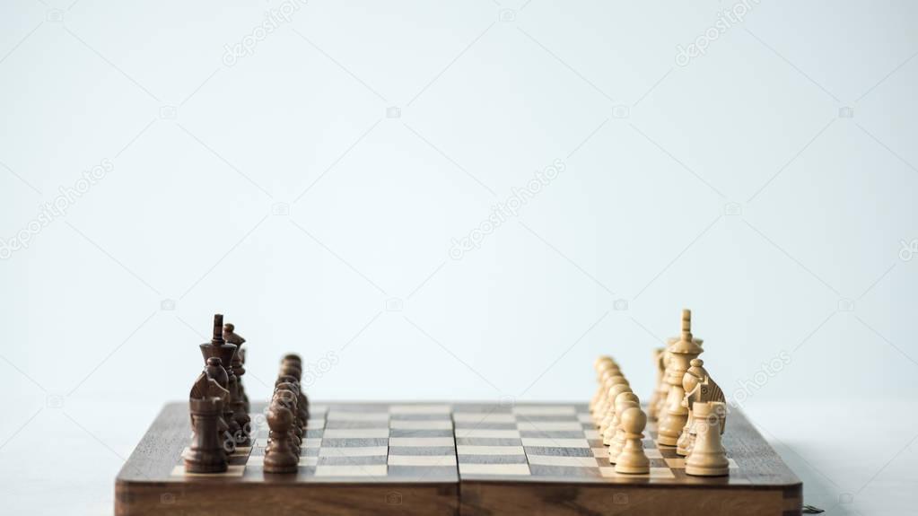 Chess board with chess pieces set for new game isolated on white