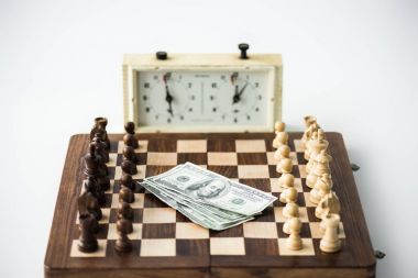 Satranç saat rakamları ve üzerinde beyaz izole Doları banknot ile satranç masası yakınındaki