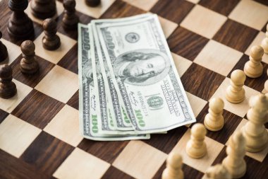 Close up view of dollar banknotes on chess board with set figures  clipart