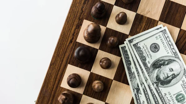 Cropped image of chessboard with cash and black chess pieces on white surface