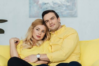 Romantik Çift oturma ve sarı koltukta kucaklayan