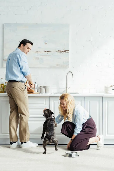 Hombre Preparando Comida Mujer Jugando Con Bulldog Francés Suelo Cocina — Foto de Stock