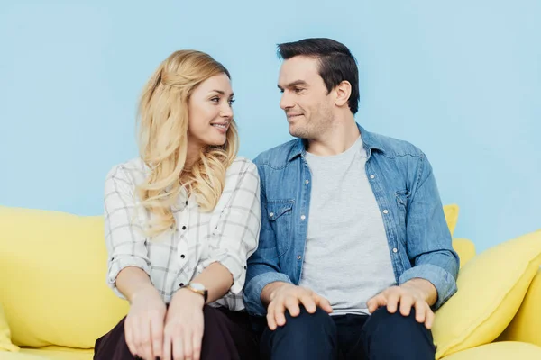 Casal Bonito Olhando Para Outro Sentado Sofá Amarelo — Fotografia de Stock