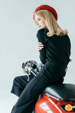 Siyah giysili gri izole kırmızı motosiklet tarafından poz çekici genç kadın