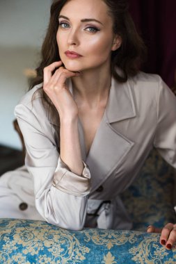 güzel kadını koltukta oturan zarif trençkot