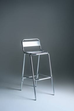 single empty metallic stool on grey clipart