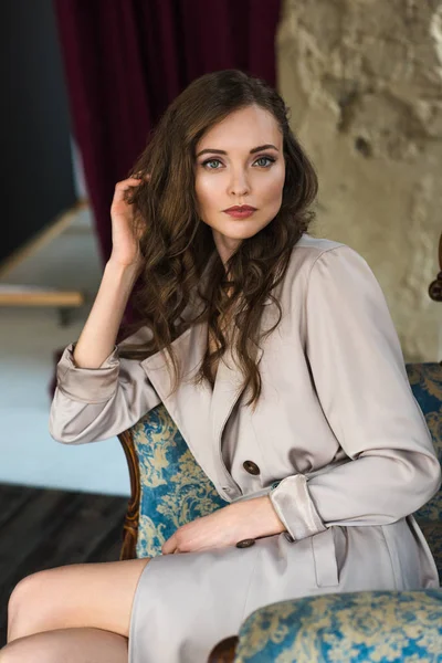 Elegante Vrouw Modieuze Trenchcoat Zitten Een Leunstoel — Stockfoto