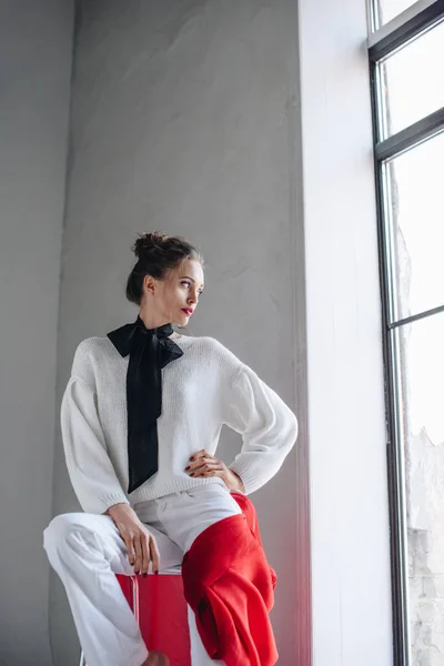 Sinnliche Junge Frau Stylischem Outfit Sitzt Mit Der Hand Auf — kostenloses Stockfoto