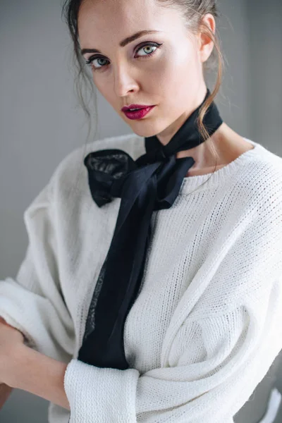 グレーのカメラ目線の首に黒いリボンを持つ官能的な若い女性の肖像画 — ストック写真