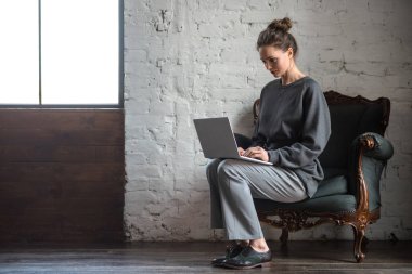 tam uzunlukta görünümü güzel şık genç kadının kapalı dizüstü bilgisayar kullanarak 