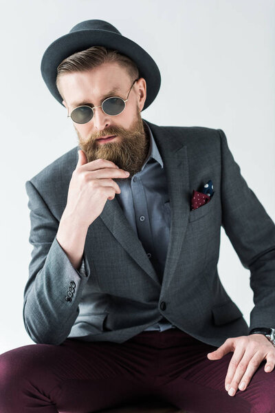 Stylish man wearing hat and sunglasses isolated on light background