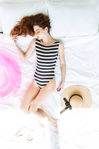 水着でビーチ オブジェクト間のベッドで寝ている赤毛の女性のトップ ビュー — ストック写真