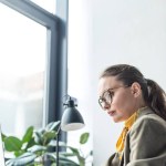 Focalizzata donna d'affari di mezza età utilizzando il computer portatile e lavorando in ufficio