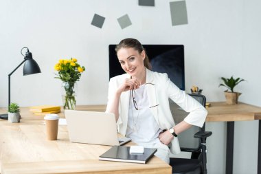 ofiste gitmek gülümseyen güzel iş kadını işyerinde laptop ve kahve ile oturan beyaz elbiseli