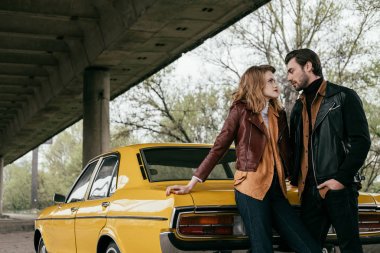 güzel genç çift birbirine duran sarı klasik otomobil yakınındaki bakarak aşık