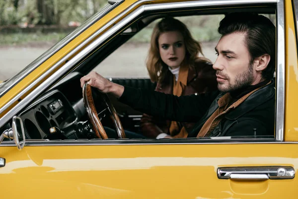 Young Woman Looking Handsome Stylish Boyfriend Driving Yellow Car — Free Stock Photo