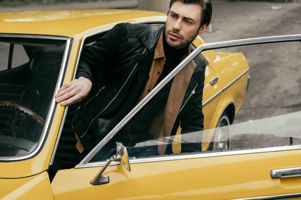 Beau Jeune Homme Élégant Cuir Veste Ouverture Porte Jaune Voiture — Photo gratuite