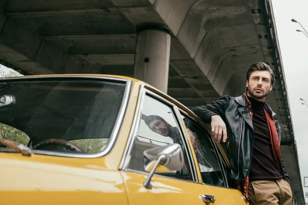 Guapo Joven Con Estilo Chaqueta Cuero Apoyado Coche Retro Mirando — Foto de Stock