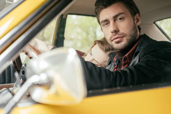 Schöner Junger Mann Schaut Die Kamera Während Mit Freundin Auto — kostenloses Stockfoto